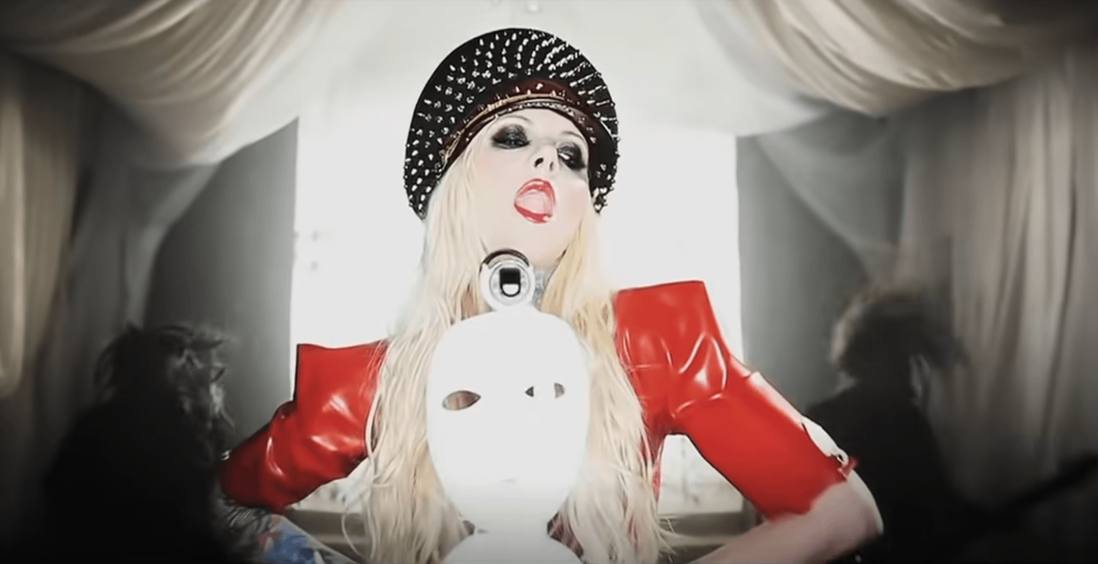Maria Brink dans le clip Blood d'In This Moment, où elle porte un képi à pics avec une veste en latex rouge