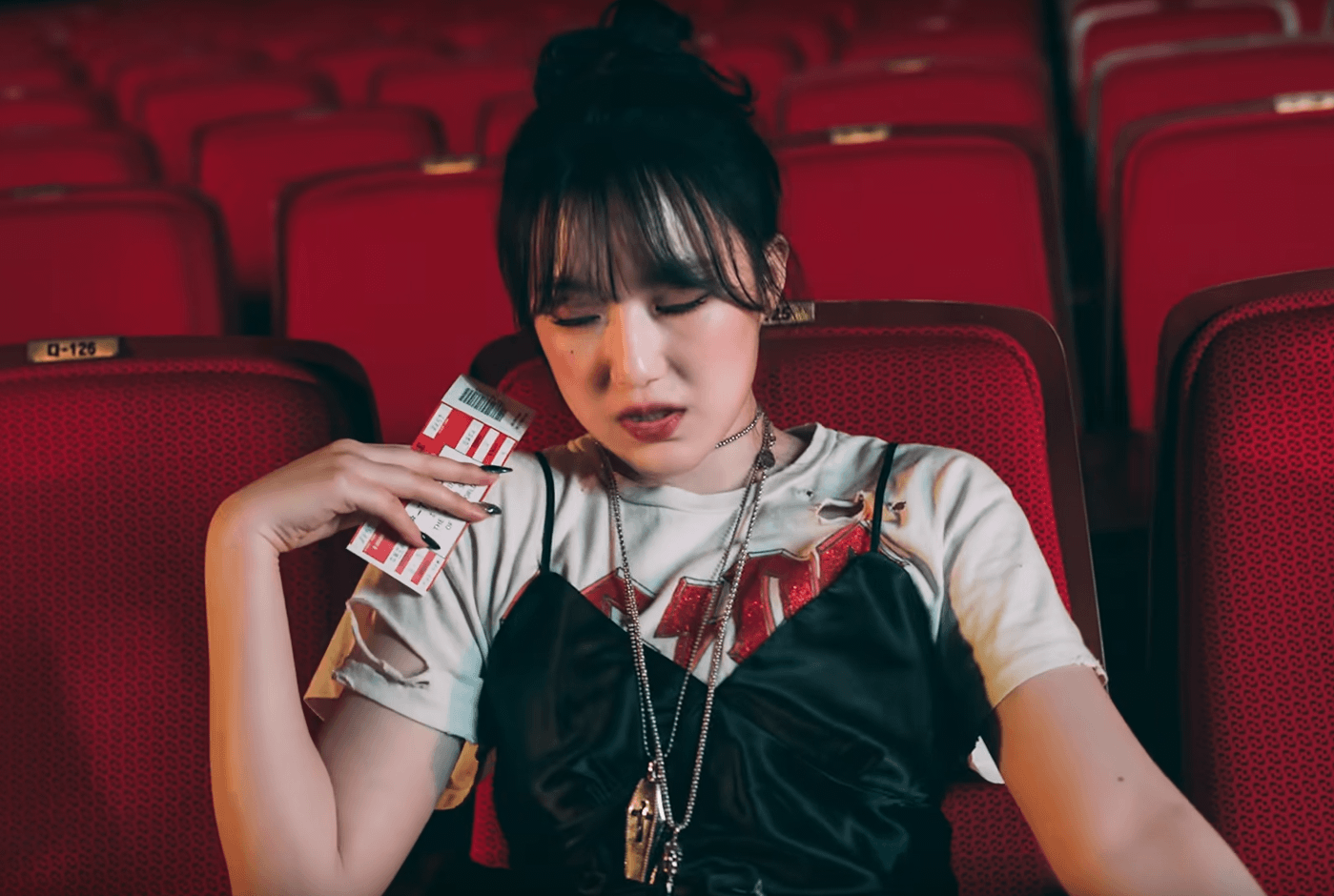 Shushua porte un tshirt ACDC blanc avec écriture rouge sous une petite robe noire