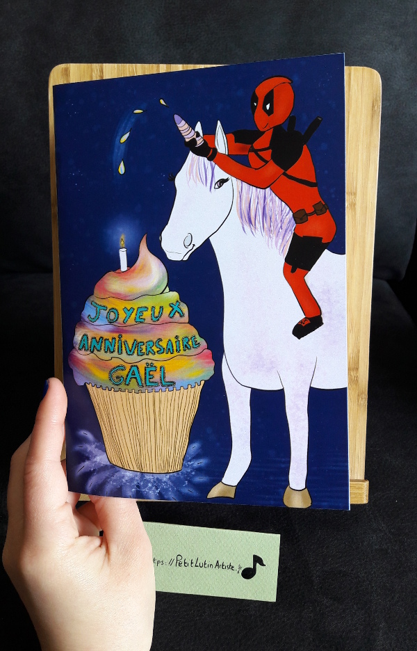 Photo de la carte d'anniversaire que j'ai réalisée en faisant un fan-art de Deadpool sur une licorne avec un cupcake