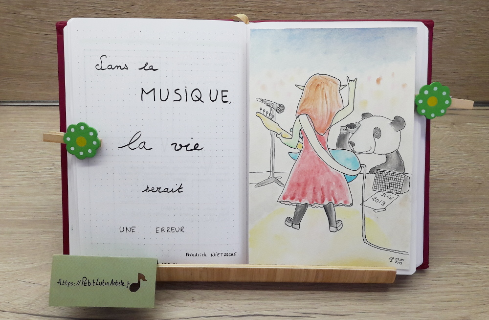 Belette Journal, mon bullet journal de juin 2019, page de gauche j'ai écrit 'Sans la musique, la vie serait une erreur', et à droite Moustache le panda prend en photo Petit Lutin alors qu'elle est sur scène et joue de la basse