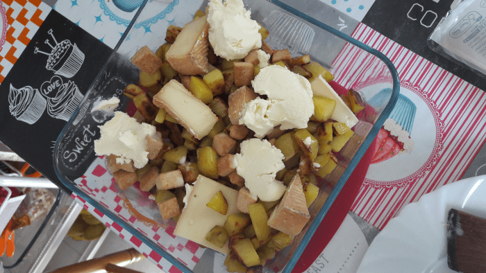dans un plat en verre qui passe au four : des patates sautées, des bouts de tofu fumé, des tranches de Munster, et un peu de crème